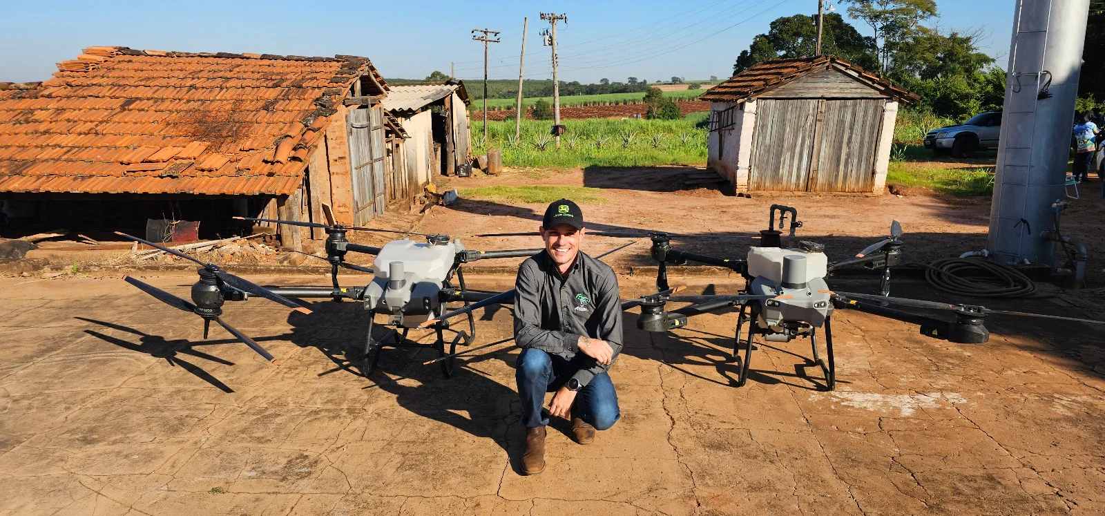 Victor Agostinho ao lado de drones agrícolas DJI Agras em operação de campo